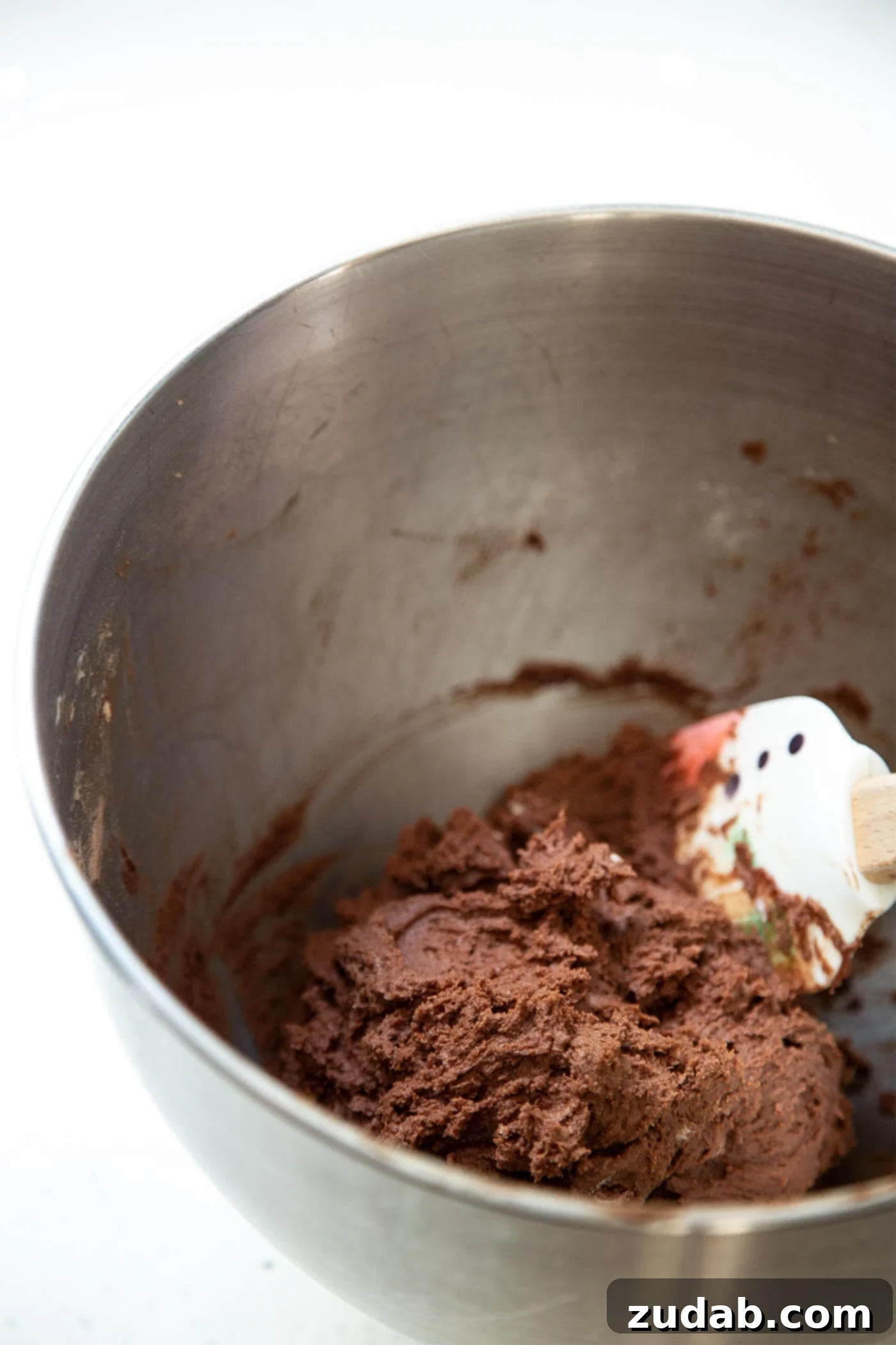 Chocolate Cookie Dough Preparation Rich chocolate cookie dough being mixed in a large stainless steel bowl with a paddle attachment