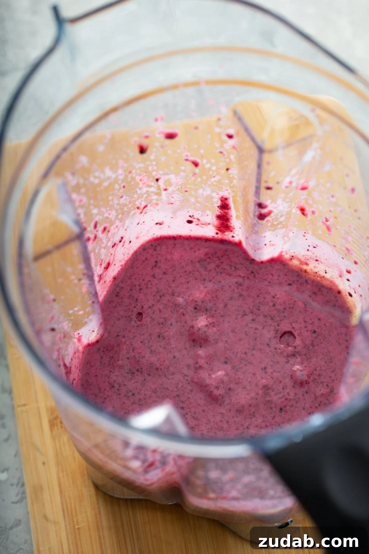 White Chocolate Berry Icebox Pie 8 A blender container with pureed filling for the pie. It is smooth, pink, and has bits of pureed berries in it.