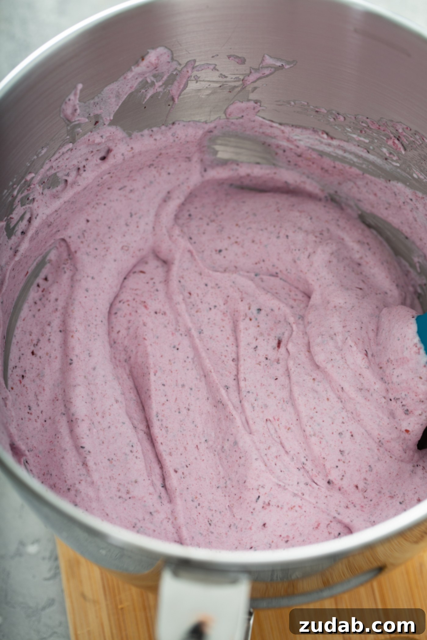 White Chocolate Berry Icebox Pie 9 A pan filled with pureed berries mixed with whipped cream. It is a whipped pink filling with bits of pureed berries.