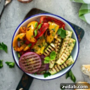 Grilled Vegetables with Balsamic Vinaigrette 15 A serving dish of grilled veggies. The zucchini wedges, sliced red onions, and red and yellow bell peppers have perfect grill marks. and the veggies have a few parsley leaves scattered on top.