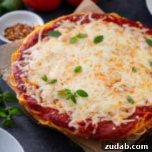 Baked Spaghetti Casserole 2 A slice of baked spaghetti pie with basil garnish on a white plate