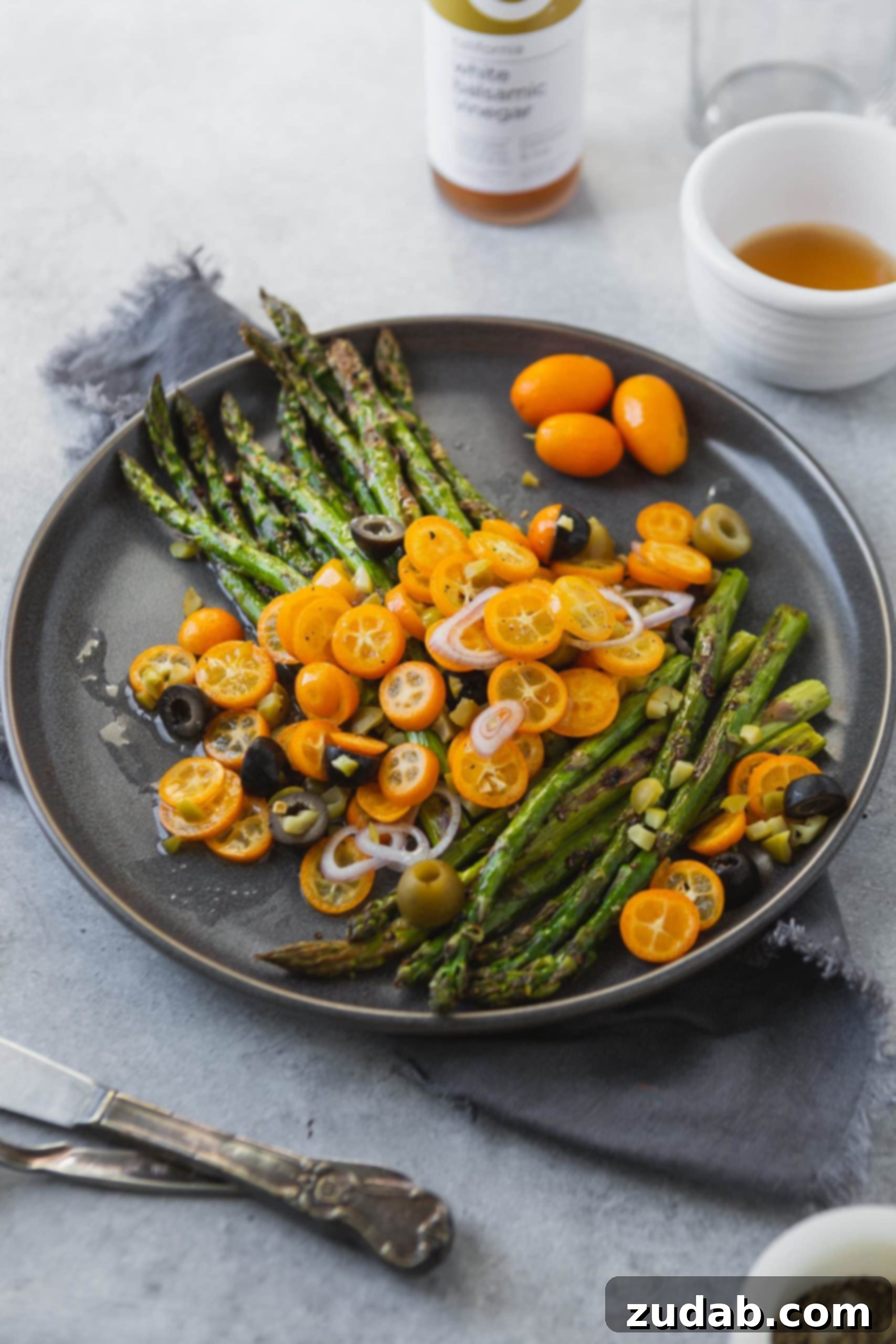 A closer view of the roasted asparagus and kumquat dish, featuring the elegant arrangement of ingredients and inviting textures.