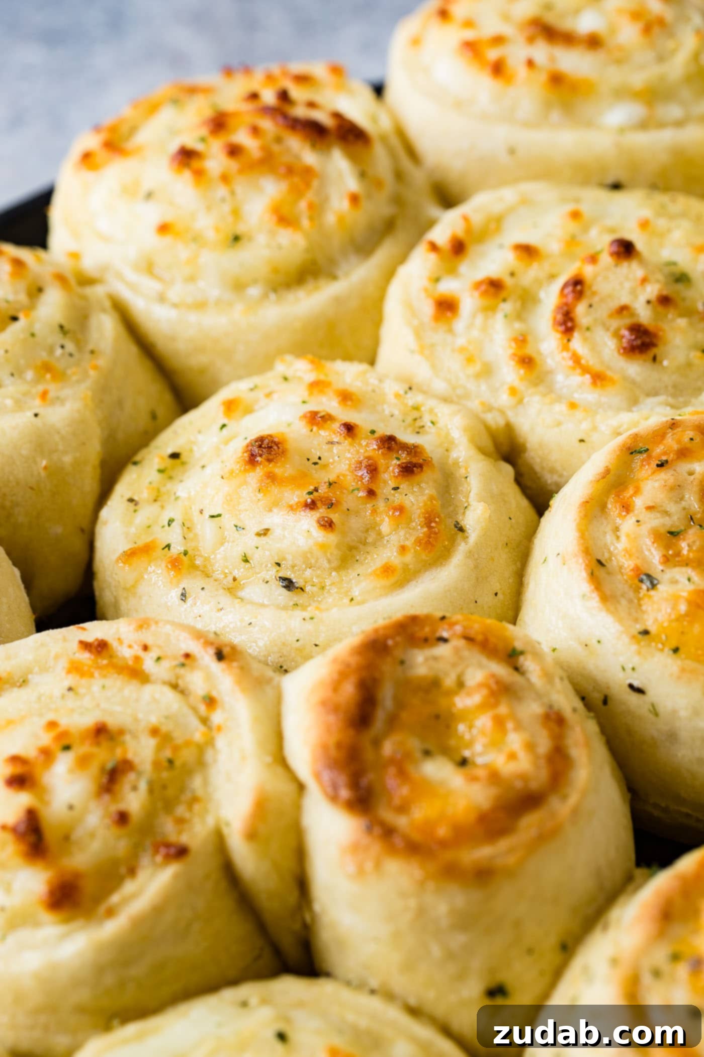 Golden Cheesy Perfection 2 A pan of golden brown baked cheese pizza rolls. The cheese doodles are like cinnamon rolls filled with mozzarella cheese.