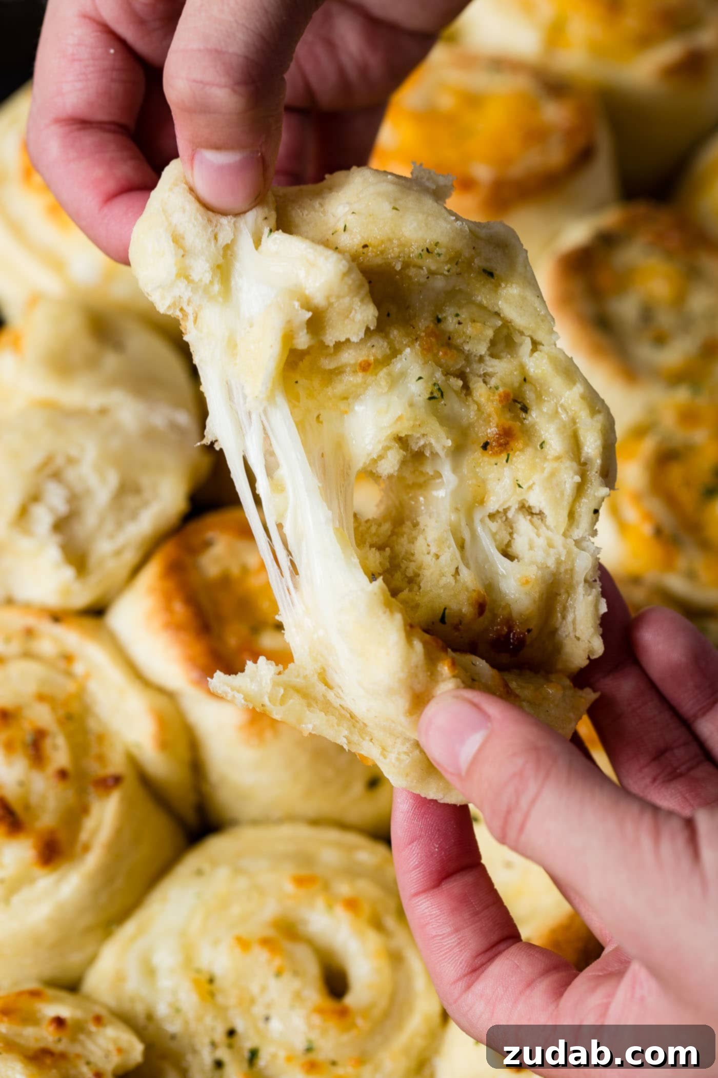 Golden Cheesy Perfection 3 A piece of cheesy garlic bread being pulled apart to expose the melted mozzarella cheese.
