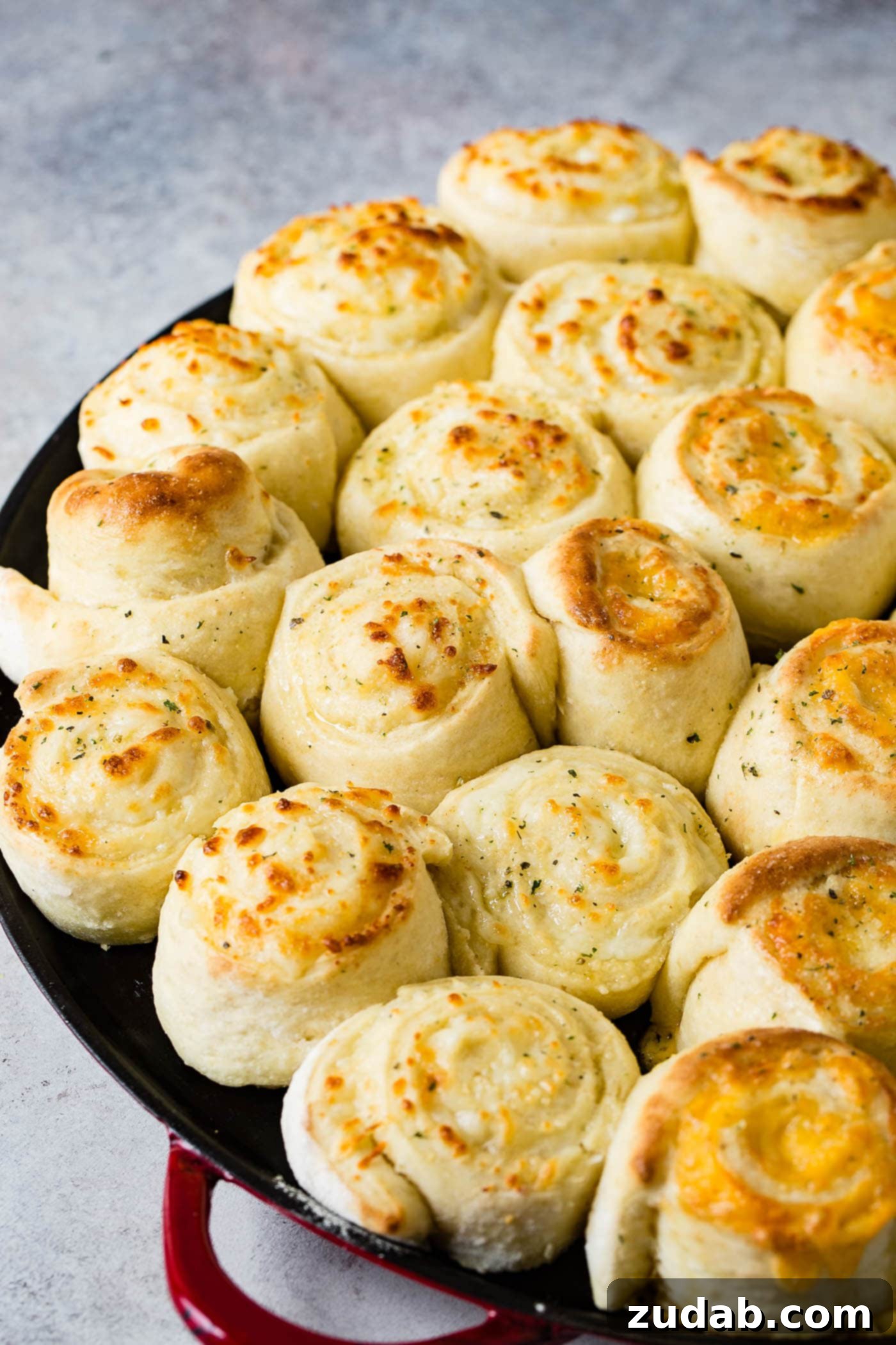 Golden Cheesy Perfection 6 A pan full of cheese doodle garlic cheesy bread. The rolls are made like cinnamon rolls and baked to a golden brown.
