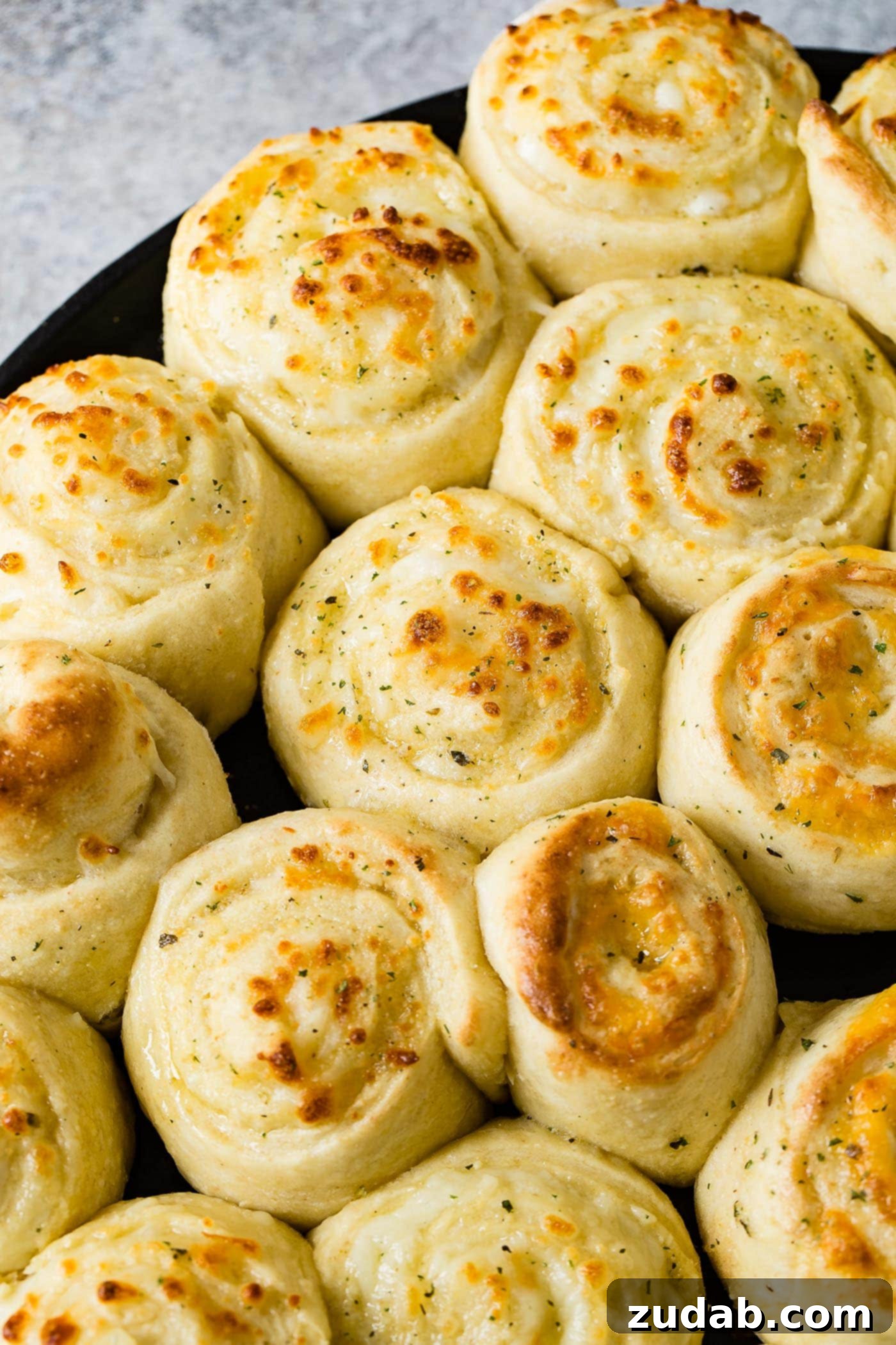 Golden Cheesy Perfection 7 A pan full of baked cheese pizza rolls. The rolls are swirled like cinnamon rolls and are baked to a golden brown.