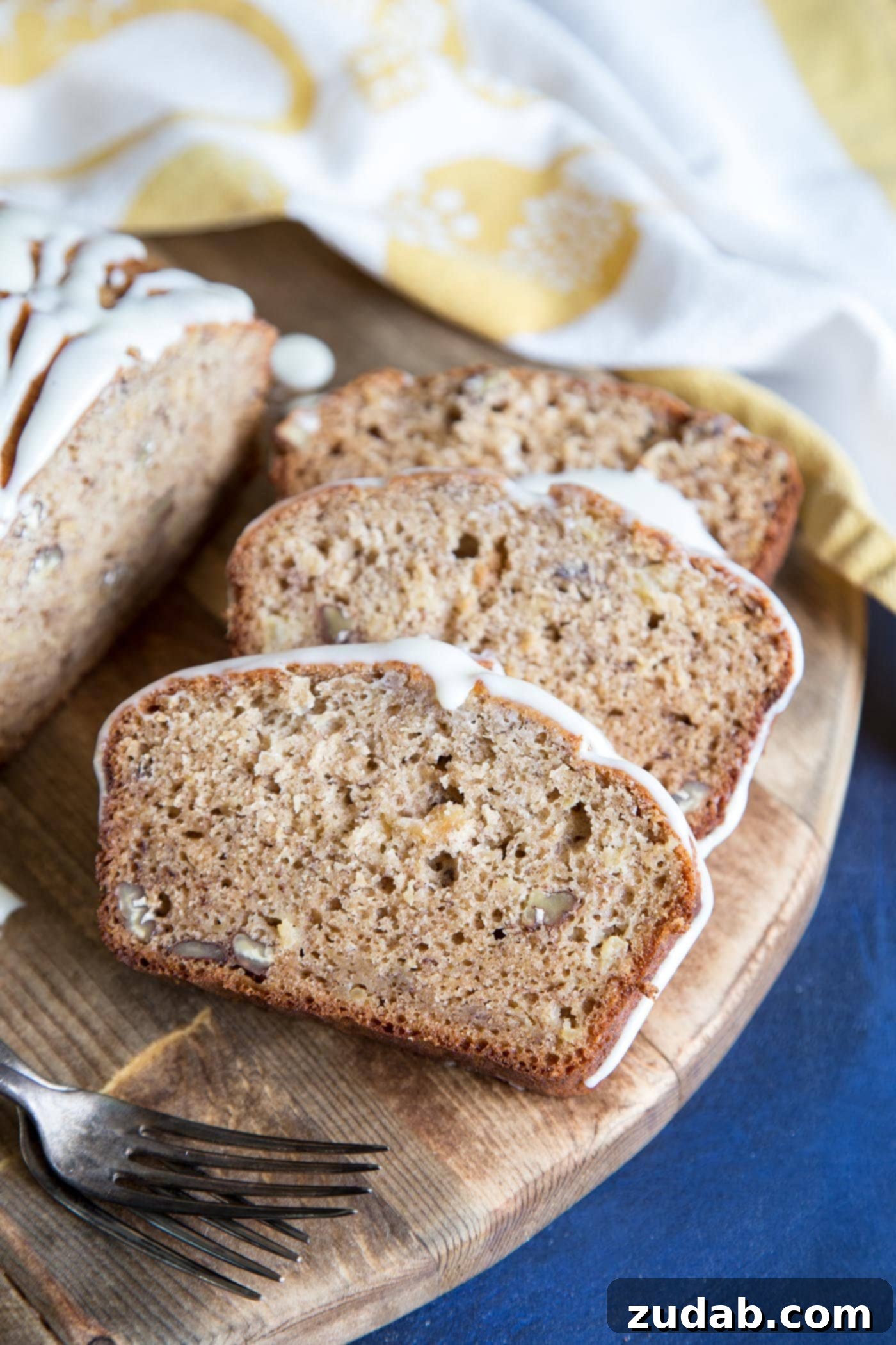 Hummingbird Banana Bread 2 Delicious slices of Hummingbird Cake Banana Bread on a rustic cutting board, ready to be enjoyed.