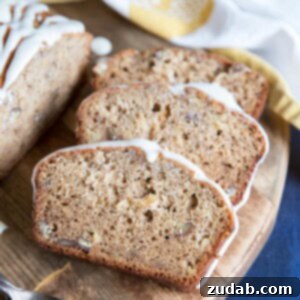 Slices of Hummingbird Cake Banana Bread on a cutting board, garnished.