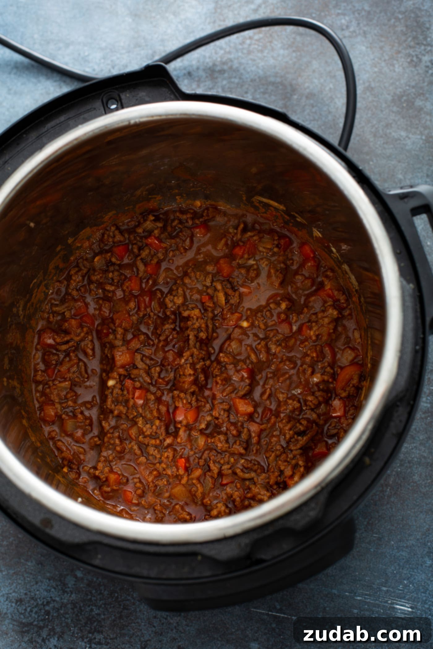 Cooked Instant Pot Sloppy Joes An Instant Pot filled with cooked sloppy joe filling, featuring browned hamburger with red bell pepper in a thick, rich, and saucy mixture, showcasing its depth of flavor.