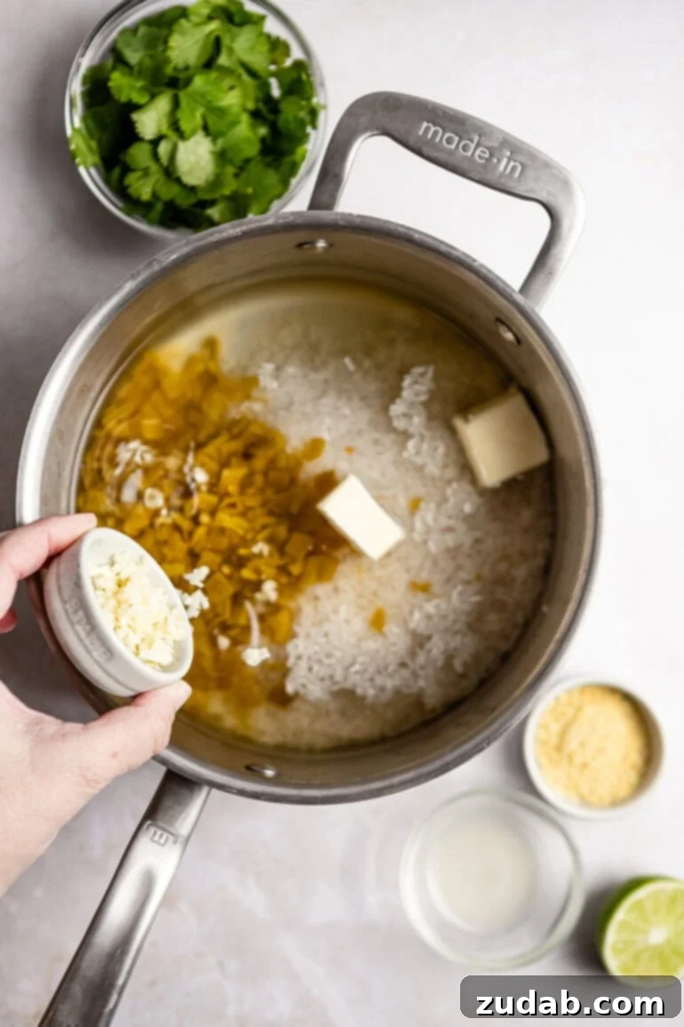 Restaurant-Quality Cilantro Lime Rice Just Like Café Rio 8 Freshly minced garlic cloves being added to the rice mixture in the saucepan, enhancing the aroma.
