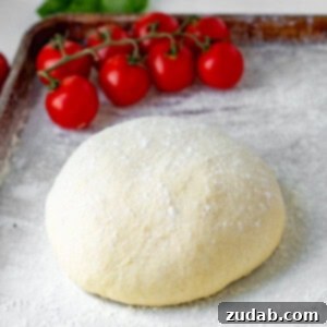 A close-up of a beautifully baked pizza dough with melted cheese and fresh basil, showcasing a perfect golden crust and inviting texture.