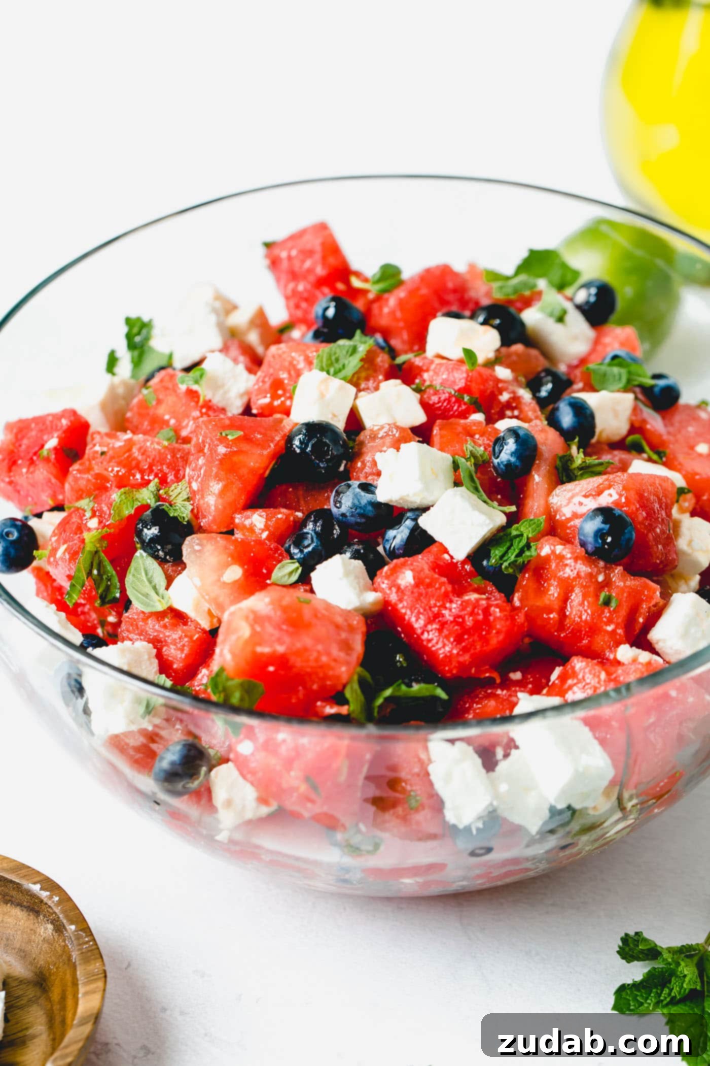 Blueberry Feta Watermelon Salad A blueberry feta watermelon salad with cubes of feta cheese and fresh basil and mint leaves.