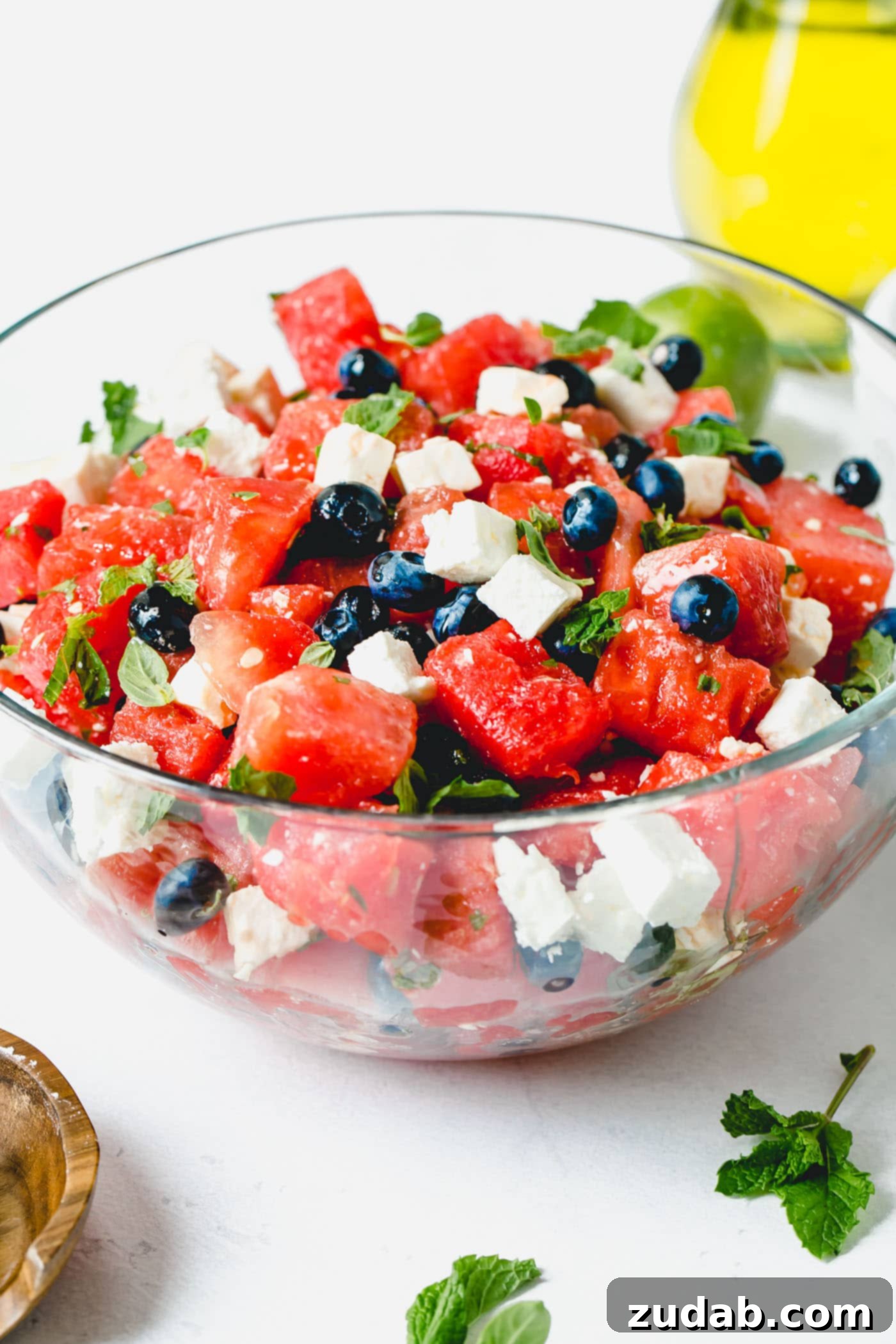 Blueberry Feta Watermelon Salad Blueberry feta watermelon salad in a glass serving bowl. There are fresh blueberries, cubes of watermelon, and cubes of feta cheese mixed with a few fresh basil and mint leaves.
