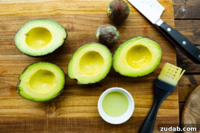 Smoky Grilled Avocado Tacos 6 a photo of several halved perfectly ripe avocados with pits removed and brushed with olive oil.