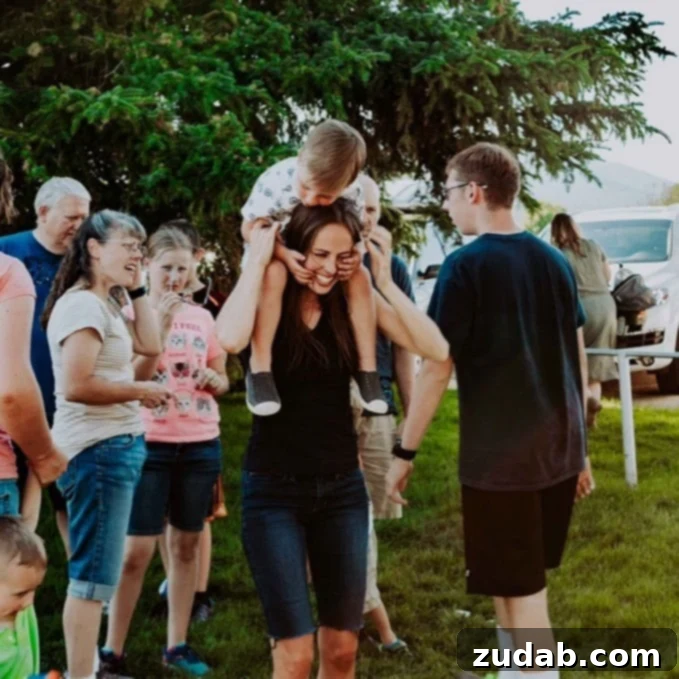 Look and Live: Navigating Faith in Uncertain Times A boy sits on his mother's shoulders, smiling amidst a lively family gathering in a park, symbolizing togetherness and pre-pandemic joy.