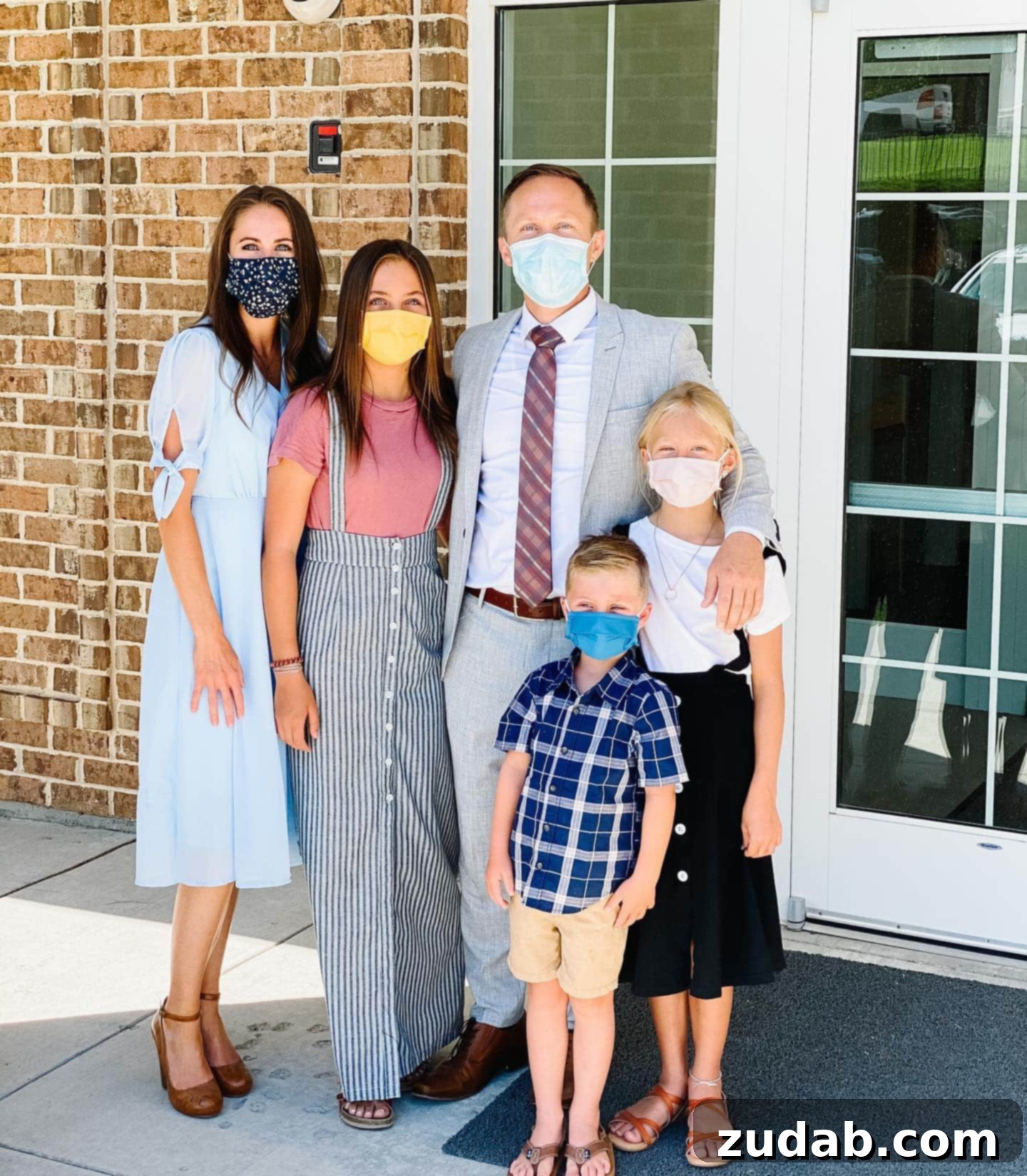 Faith to be Obedient Amidst Change A family, including a mother and three children, stands outside a church building, all wearing face masks, reflecting modern worship challenges.