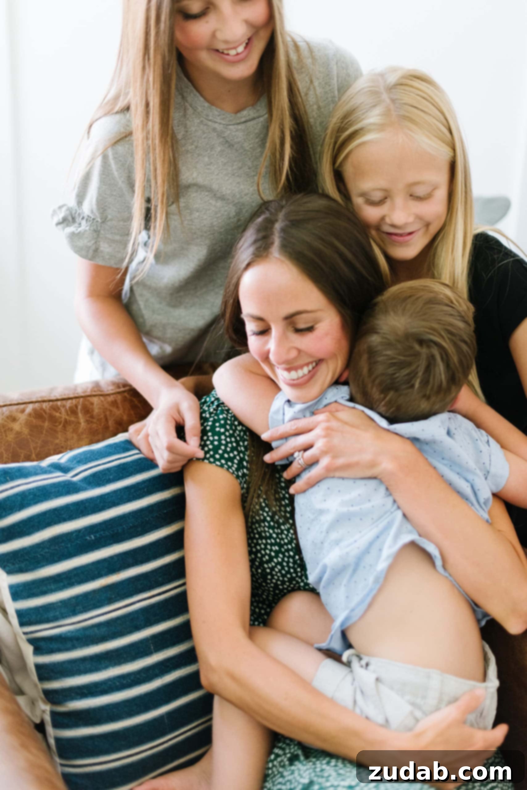 Just Like You and I a mother hugging her young son with her older two daughters looking on.