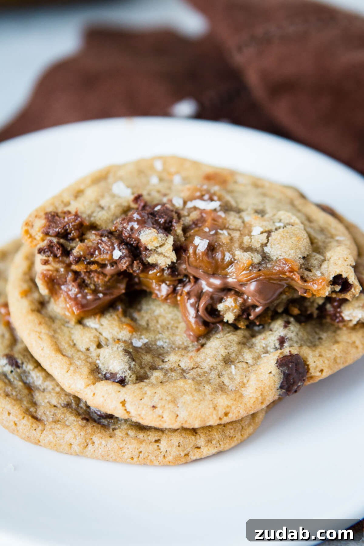 Decadent Nutella and Dulce De Leche Stuffed Chocolate Chip Cookies 2 Brown butter chocolate chip cookies stuffed with nutella and dulce de leche and sprinkled with sea salt. Best cookies ever!!! ohsweetbasil.com