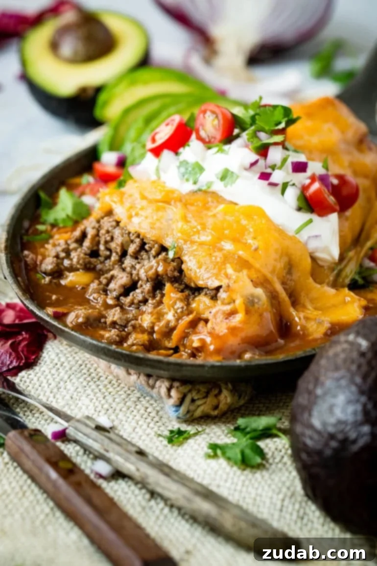Weeknight Enchilada Beef Burritos 2 A perfectly wrapped tortilla, drenched in deep red enchilada sauce and covered with glistening, golden melted cheese, ready to be served.