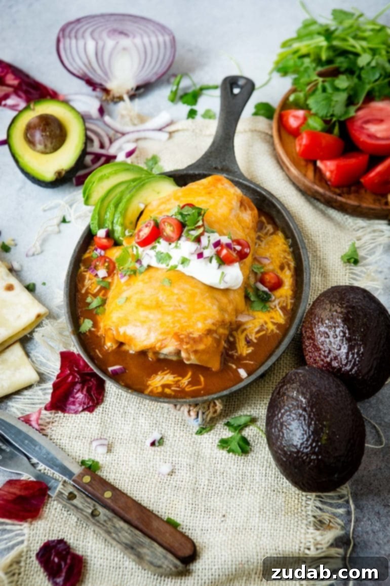 Weeknight Enchilada Beef Burritos 4 A bubbling, cheesy smothered burrito baked to golden perfection in a cast iron pan, surrounded by rich red sauce and topped with perfectly melted cheese.