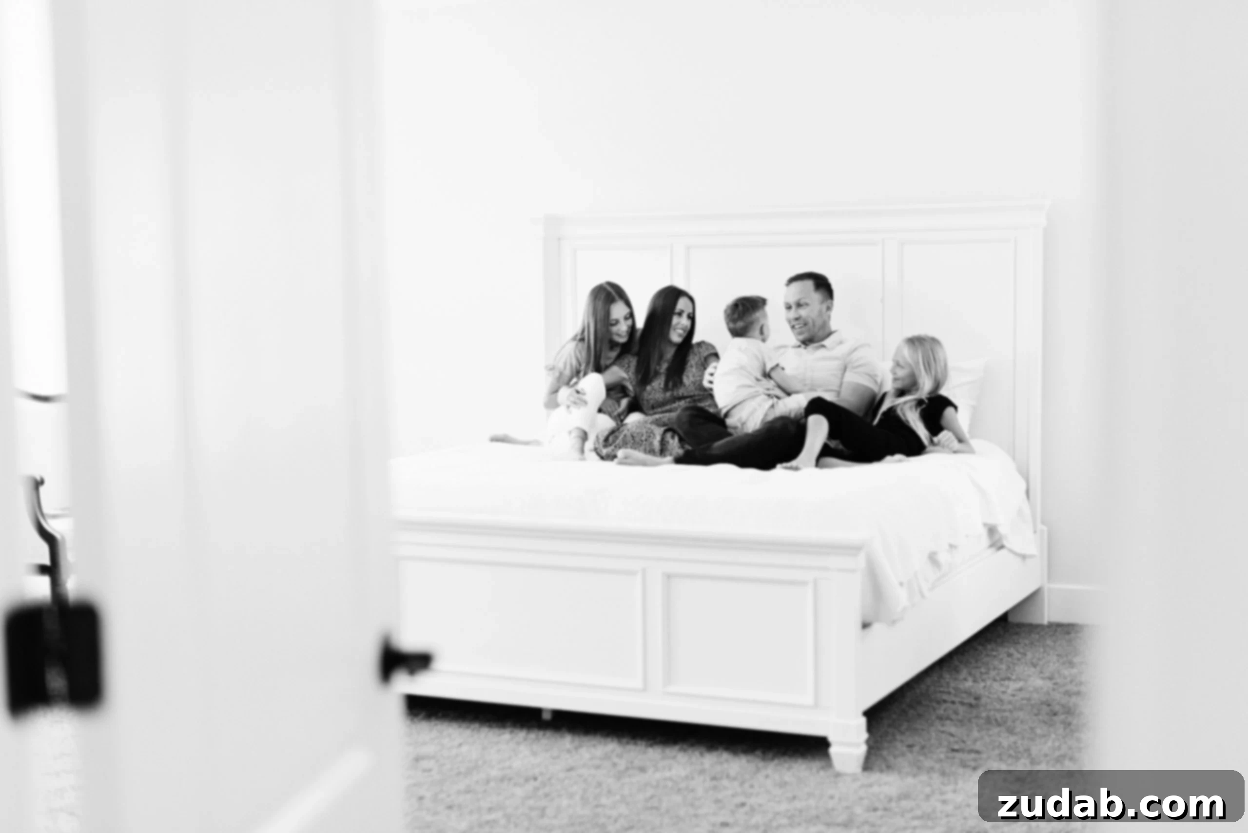 Now is the Time to Listen a family sitting on a large white bed enjoying time together