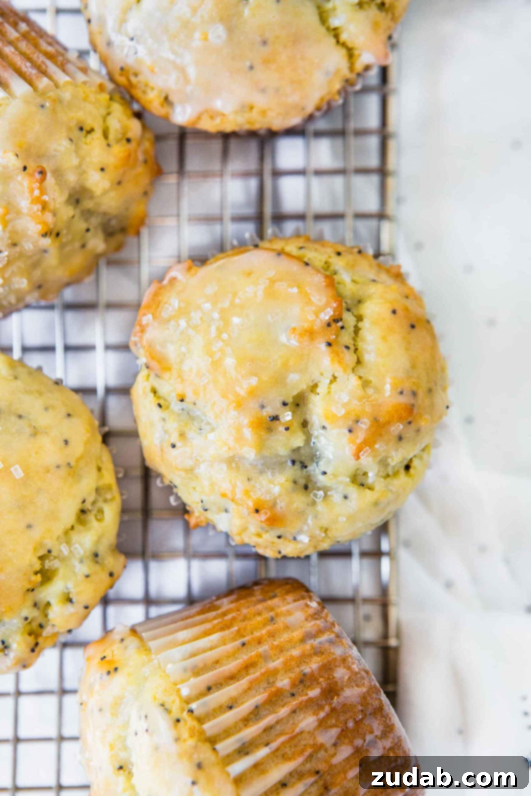 Lemon Poppy Seed Muffins Lemon poppy seed muffins sitting on a wire cooling rack. They have a lemon glaze on top.