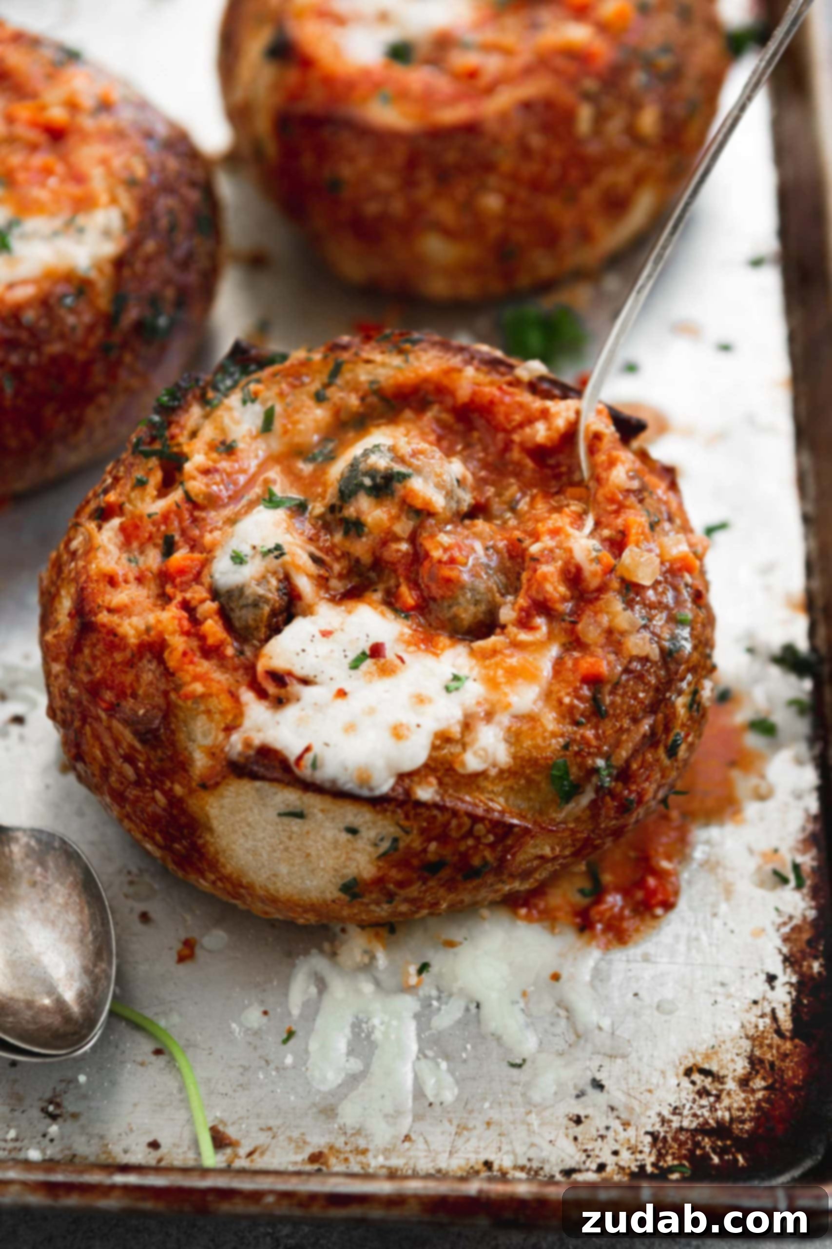 Parmesan Meatball Soup A bread bowl filled with parmesan meatball soup. The bread bowl and soup have been baked to a perfect toasty brown and the cheese on top is gooey melted perfection.