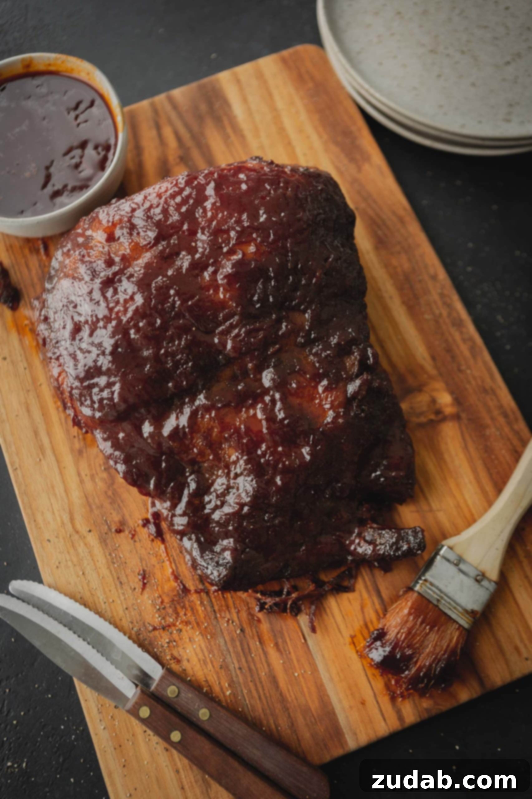 Slow Cooker Beef Brisket A BBQ slow cooker brisket on a cutting board with a brush next to it.