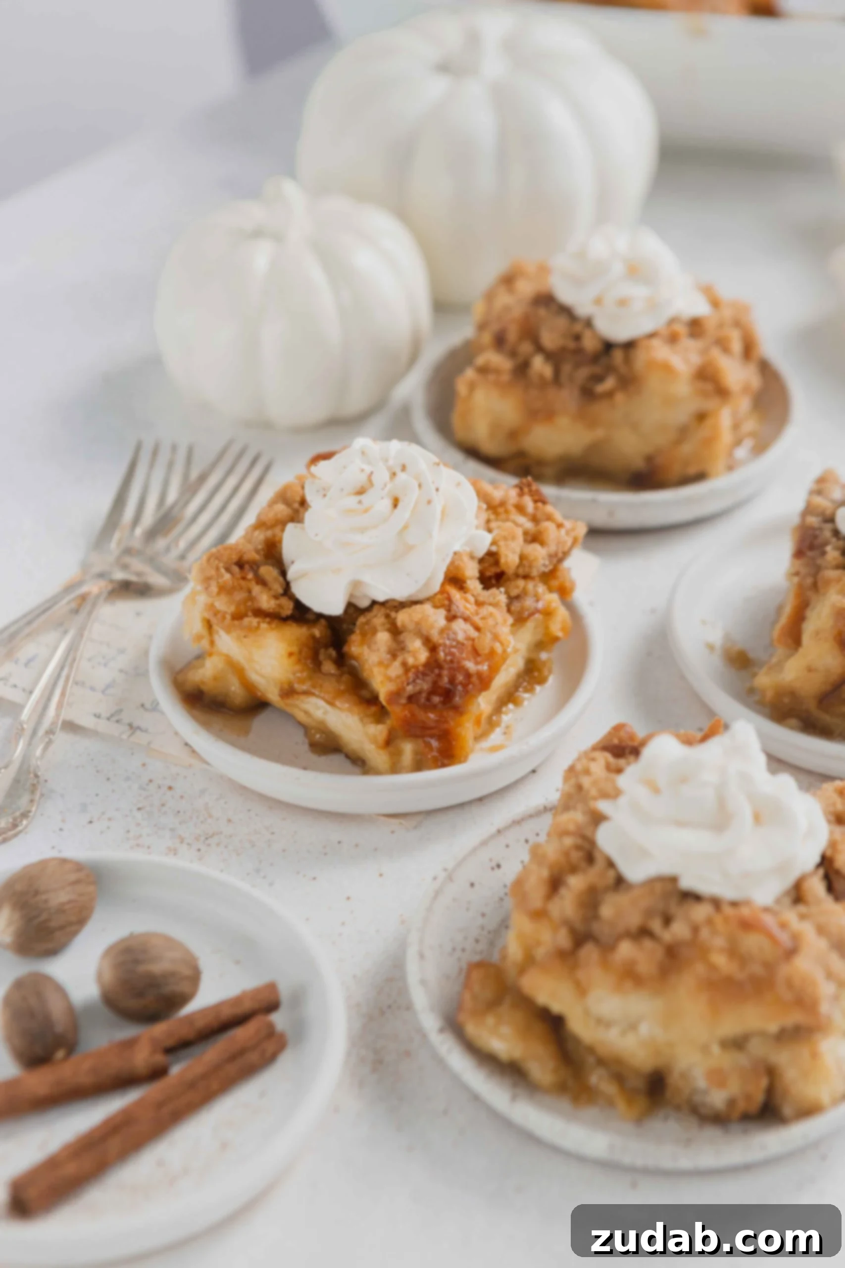 Eggnog French Toast Casserole Servings of eggnog French toast casserole on white plates. The casserole is topped with a dollop of fresh whipped cream.