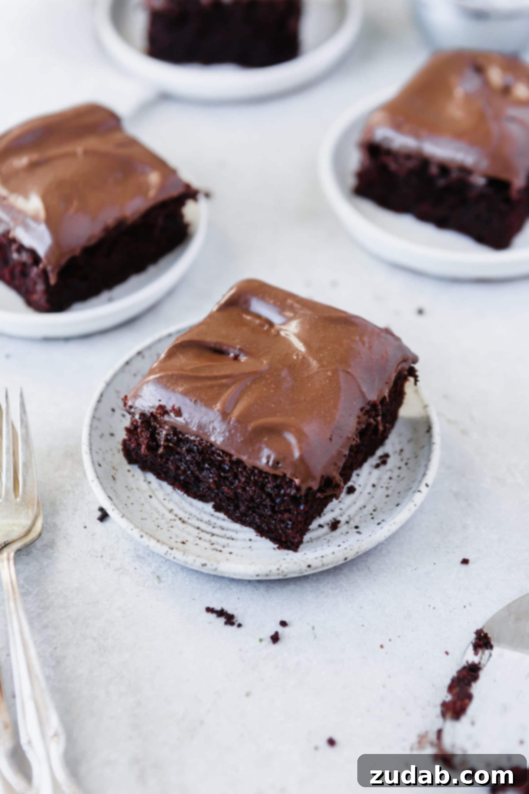 Easy Chocolate Mayonnaise Cake Three white dessert plates each holding a serving of chocolate mayonnaise cake with chocolate cream cheese frosting.