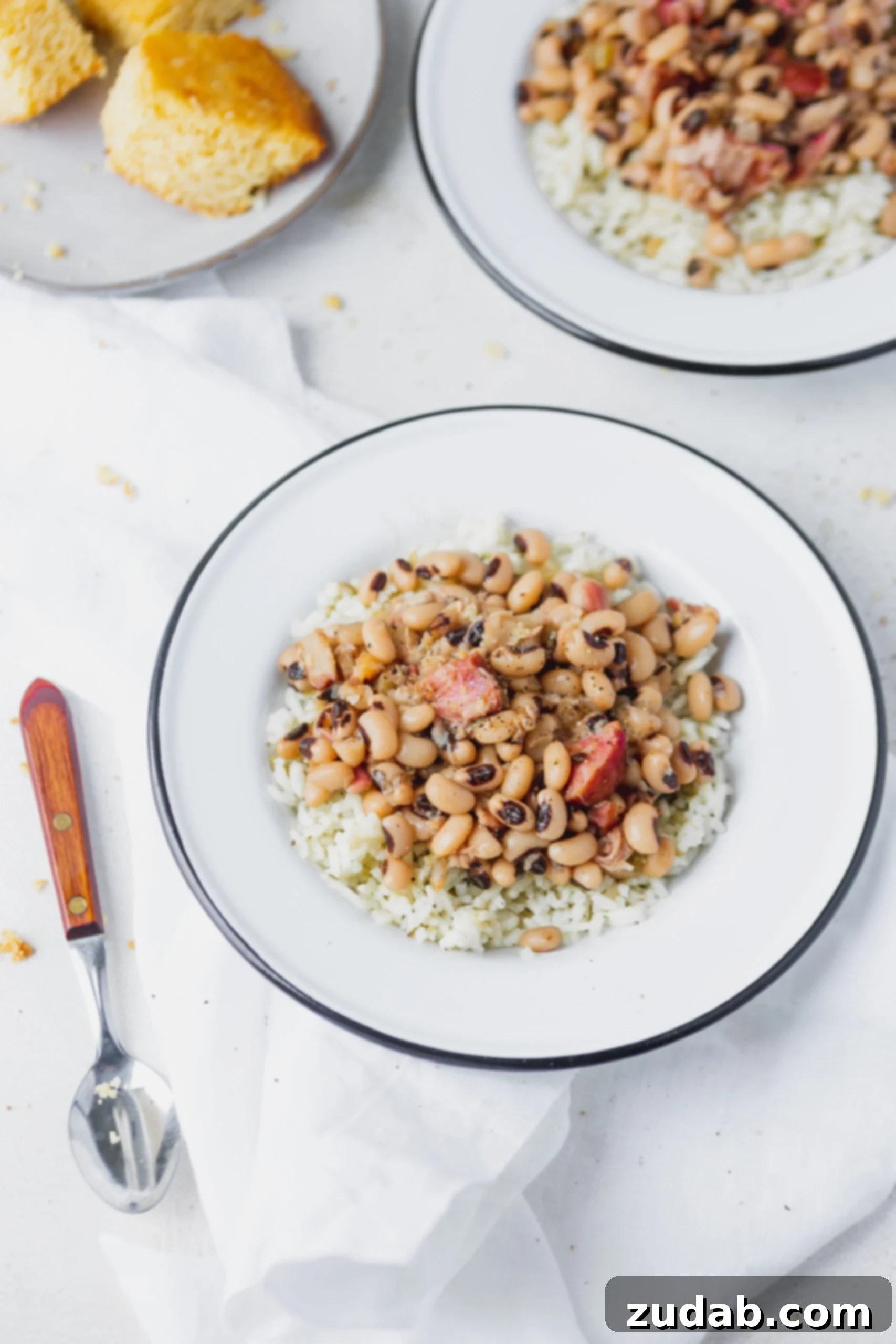 Instant Pot Black Eyed Peas A white plate with instant pot black eyed beans over rice. A spoon is next to the plate.