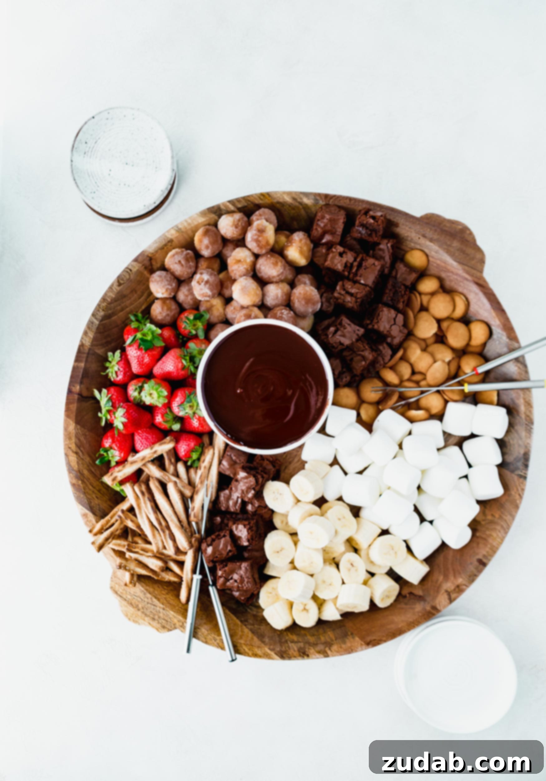 Chocolate Fondue A beautifully presented tray featuring a central bowl of irresistible chocolate fondue, surrounded by an abundant selection of dippers including fresh strawberries, ripe banana slices, chewy brownie bites, fluffy marshmallows, and assorted cookies, all ready for a delicious dipping party.