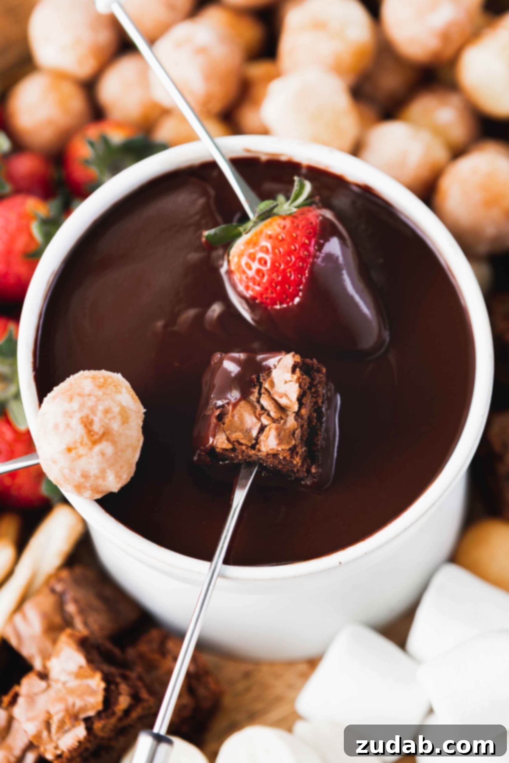 Chocolate Fondue A mesmerizing close-up of a bowl of chocolate fondue, capturing the moment a fresh strawberry, a soft brownie bite, and a fluffy donut hole are being dipped simultaneously. The rich, melted chocolate glistens, inviting endless indulgence. This image emphasizes the versatility of dipper choices.