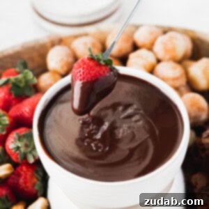 A close-up image of a decadent chocolate fondue in a small, elegant pot, ready for dipping. The rich, smooth surface of the chocolate hints at its luxurious texture, with a subtle sheen that makes it irresistible. This image serves as a visual centerpiece for the recipe, showcasing the final product in its most inviting form.