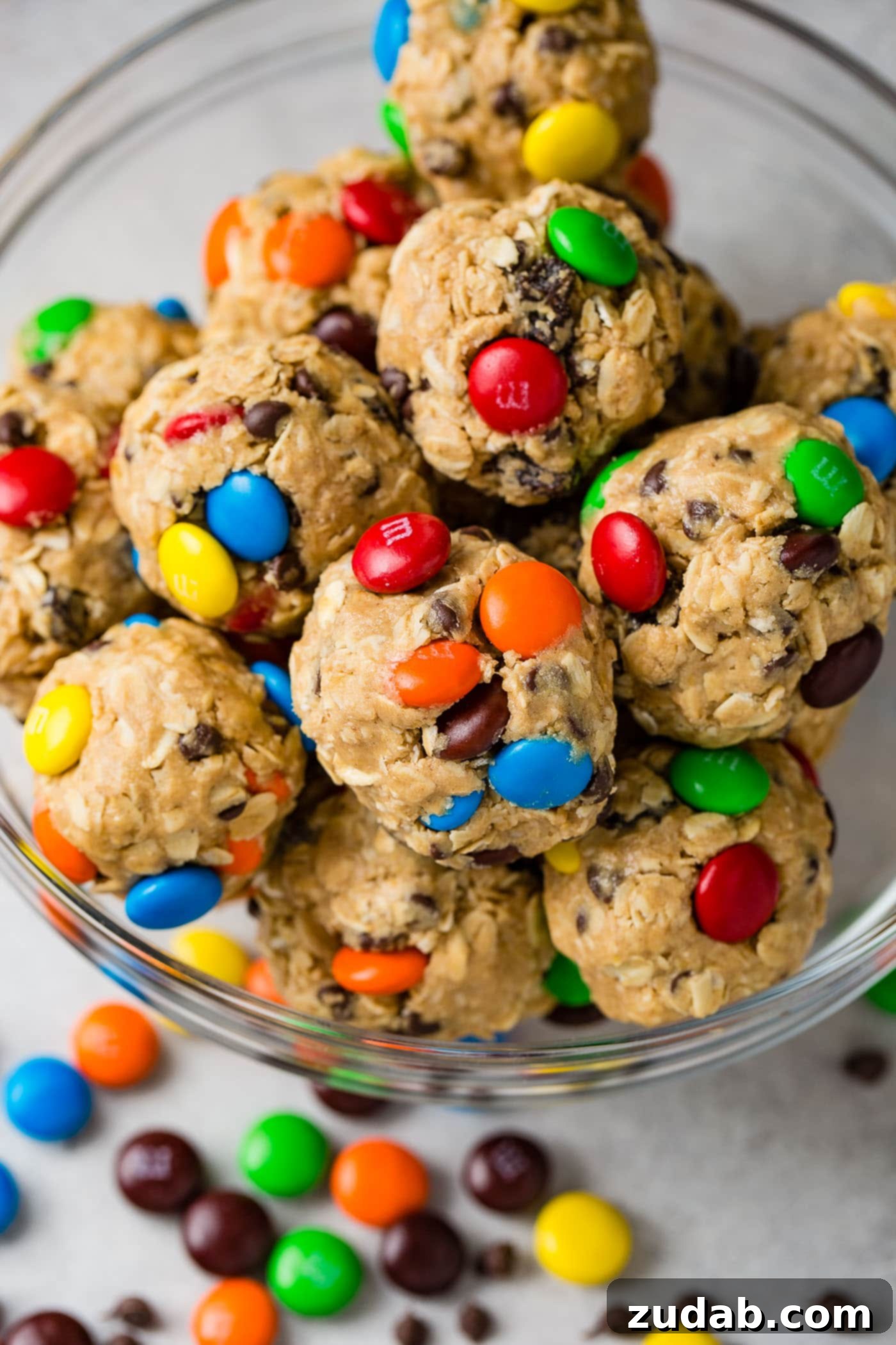 Over 25 Healthy Recipes 23 A bowl heaped full of colorful Monster Cookie Protein Balls, packed with mini M&Ms, raisins, and mini chocolate chips.