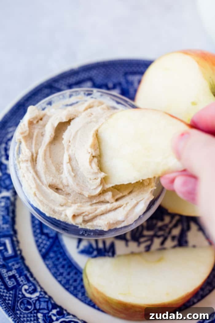Over 25 Healthy Recipes 25 A blue dish holding sliced apples and half an apple, accompanied by a small bowl of creamy peanut butter Greek yogurt dip.