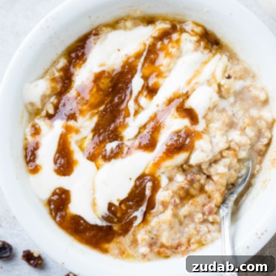 Over 25 Healthy Recipes 4 A white bowl of cinnamon roll oatmeal with a swirl of butter and brown sugar mixture and a creamy cream cheese glaze, served with a vintage spoon.