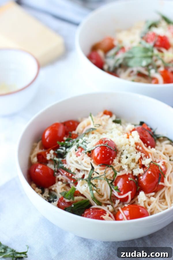 Over 25 Healthy Recipes 9 A serving of cherry tomato and basil angel hair pasta, garnished with fresh basil leaves, in a white bowl.
