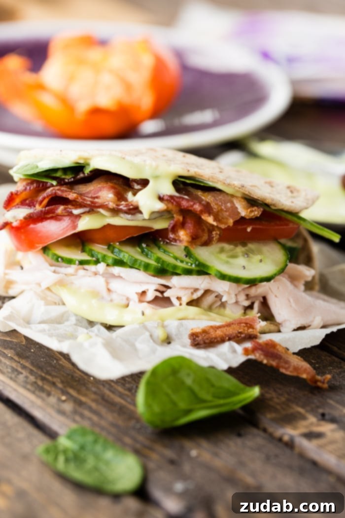 Over 25 Healthy Recipes 10 A flatbread sandwich filled with turkey, bacon, creamy avocado dressing, cucumbers, tomatoes, and spinach, sprinkled with chia seeds.
