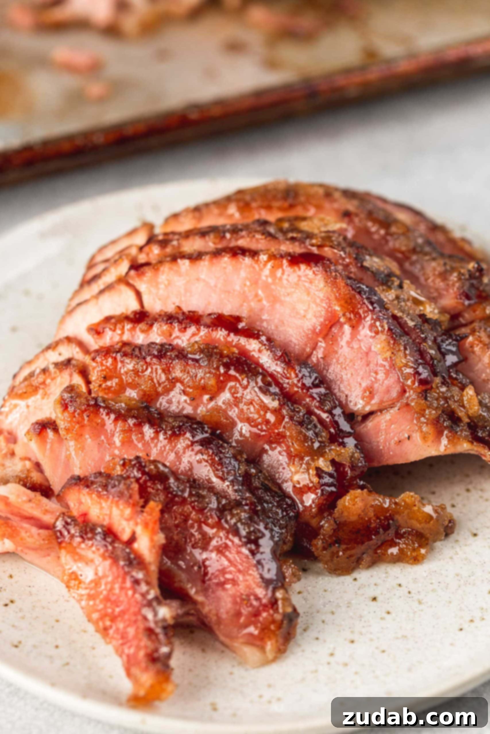 A beautifully spiral-cut honey glazed ham, with slices slightly separated to showcase the juicy meat and sticky, golden glaze.