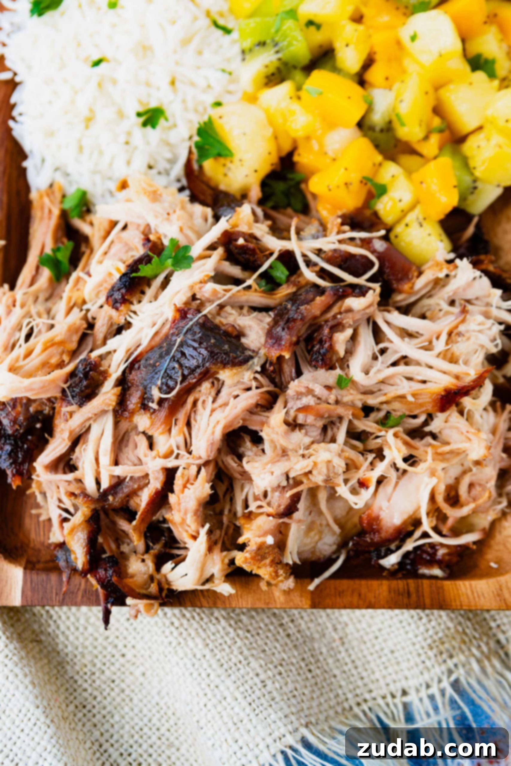 Slow Cooker Kalua Pork Recipe a photo of tender, juicy kalua pulled pork on a wooden serving platter