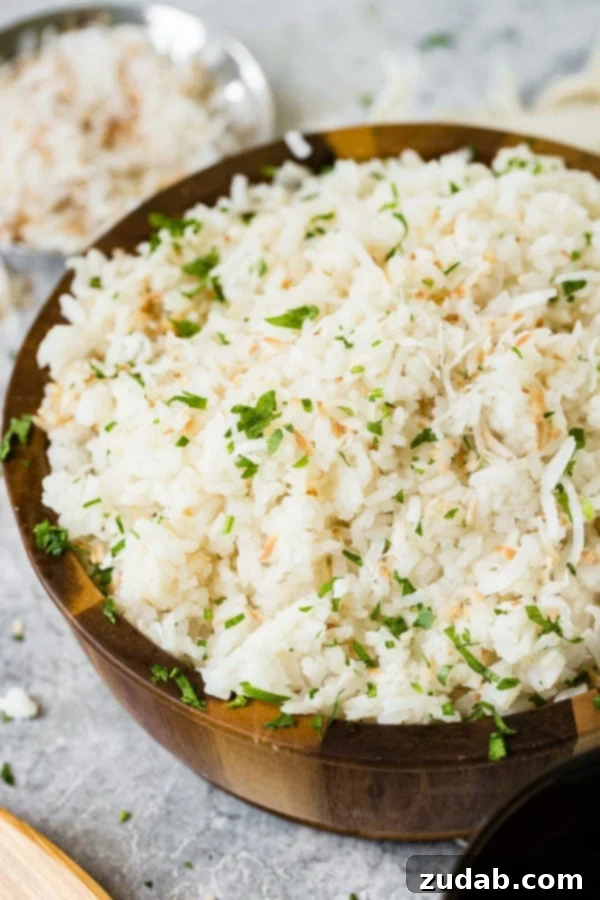 Tropical Brazilian Coconut Rice 2 A photo of Brazilian coconut rice in a large wooden bowl and garnished with chopped fresh basil.