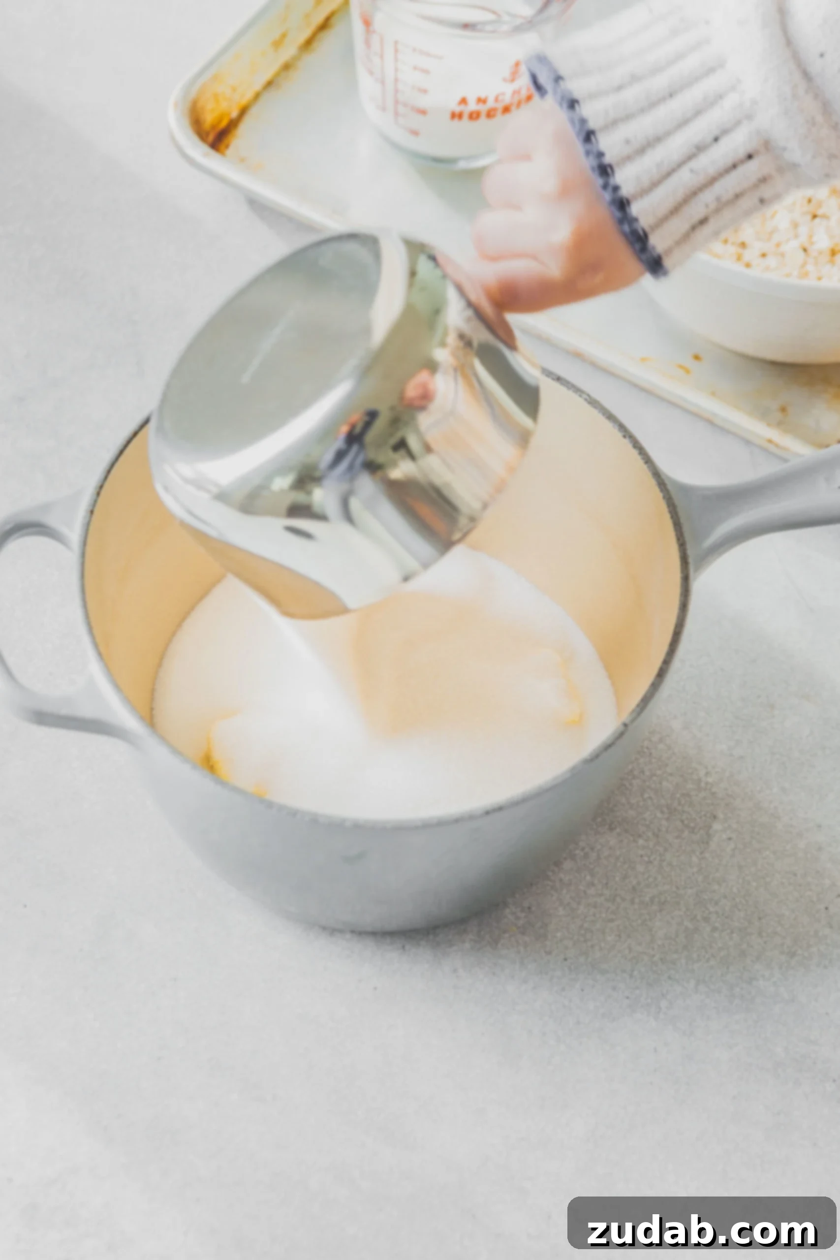 A sauce pan containing sugar, milk and butter.