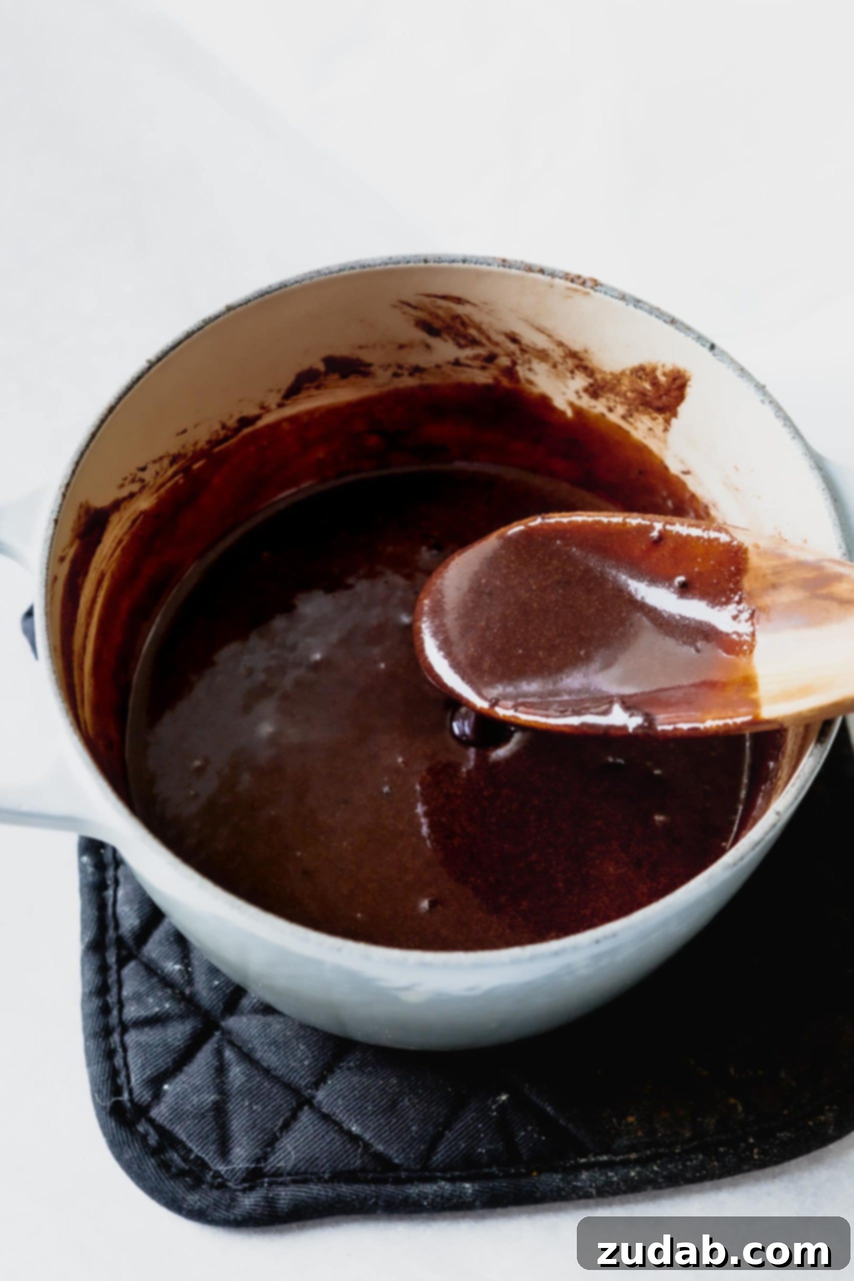 A saucepan with milk, sugar, butter and cocoa that has all been melted together.