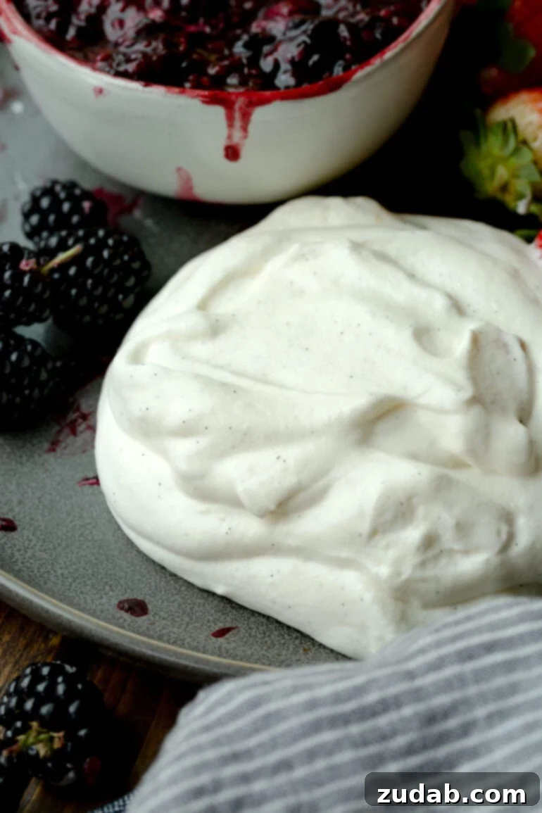 Dreamy Vanilla Bean Whipped Cream 2 a photo of a pile of perfectly whipped vanilla bean whipped cream with marscapone sitting next to fresh berries