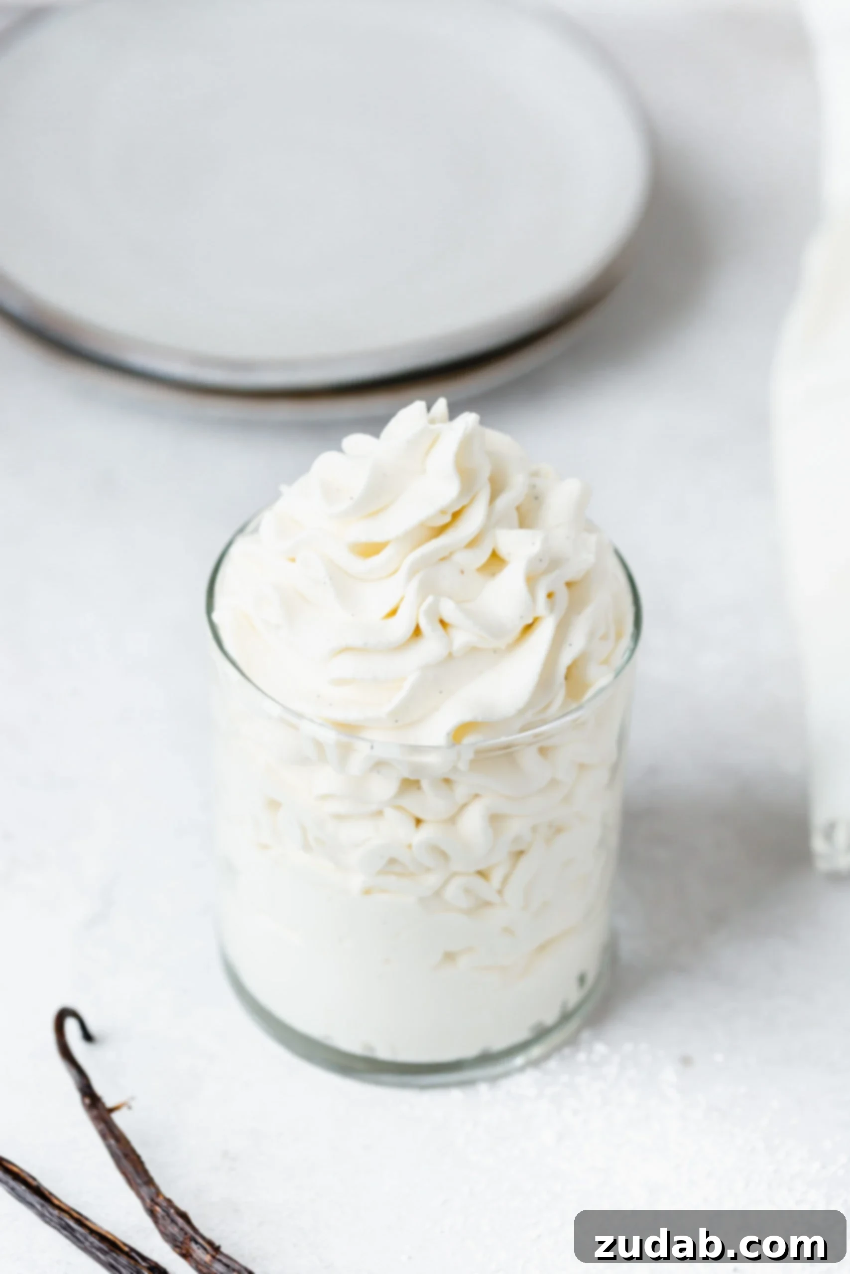 Vanilla Bean Whipped Cream A glass container of mascarpone vanilla bean whipped cream.