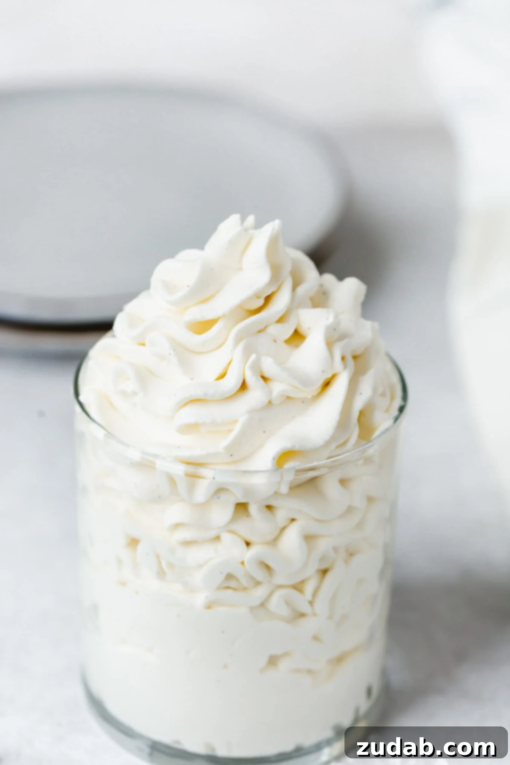 Vanilla Bean Whipped Cream A glass filled with mascarpone vanilla whipped cream. It is fluffy and white.