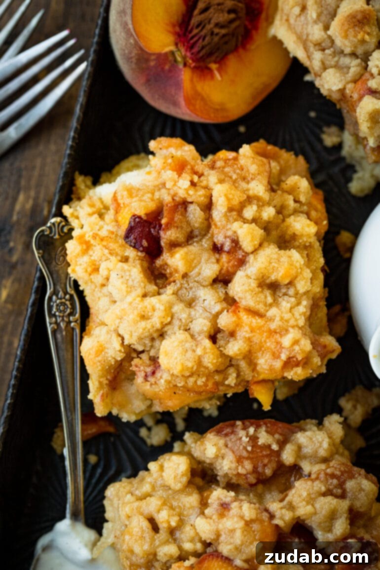 Delicious Peach Cobbler French Toast 11 A photo taken over the top of a serving of golden baked peach cobbler french toast casserole, highlighting its inviting layers and textures.