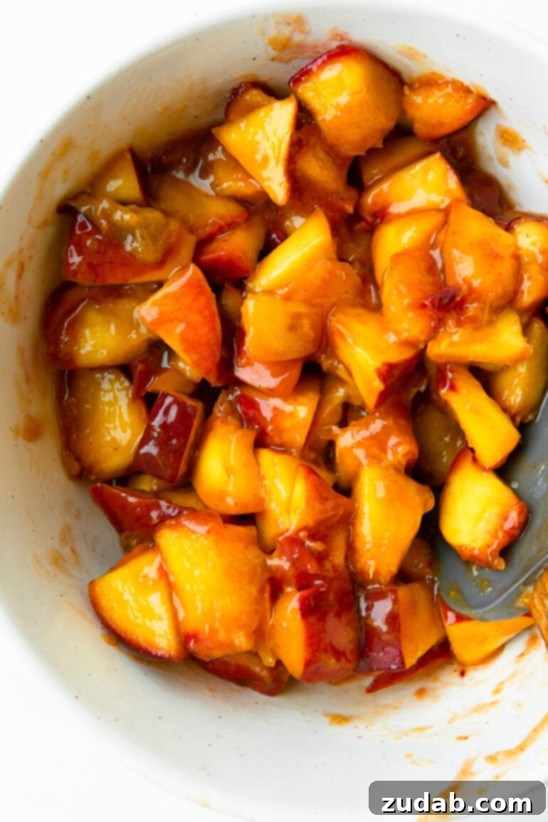 Delicious Peach Cobbler French Toast 6 A dish of French toast casserole showing a generous layer of peaches and the baked bread base.