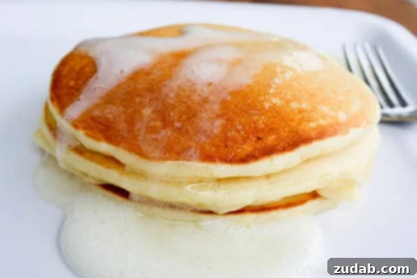 Fluffy Meyer lemon Greek yogurt pancakes topped with zesty Meyer lemon syrup, a bright and refreshing breakfast option.